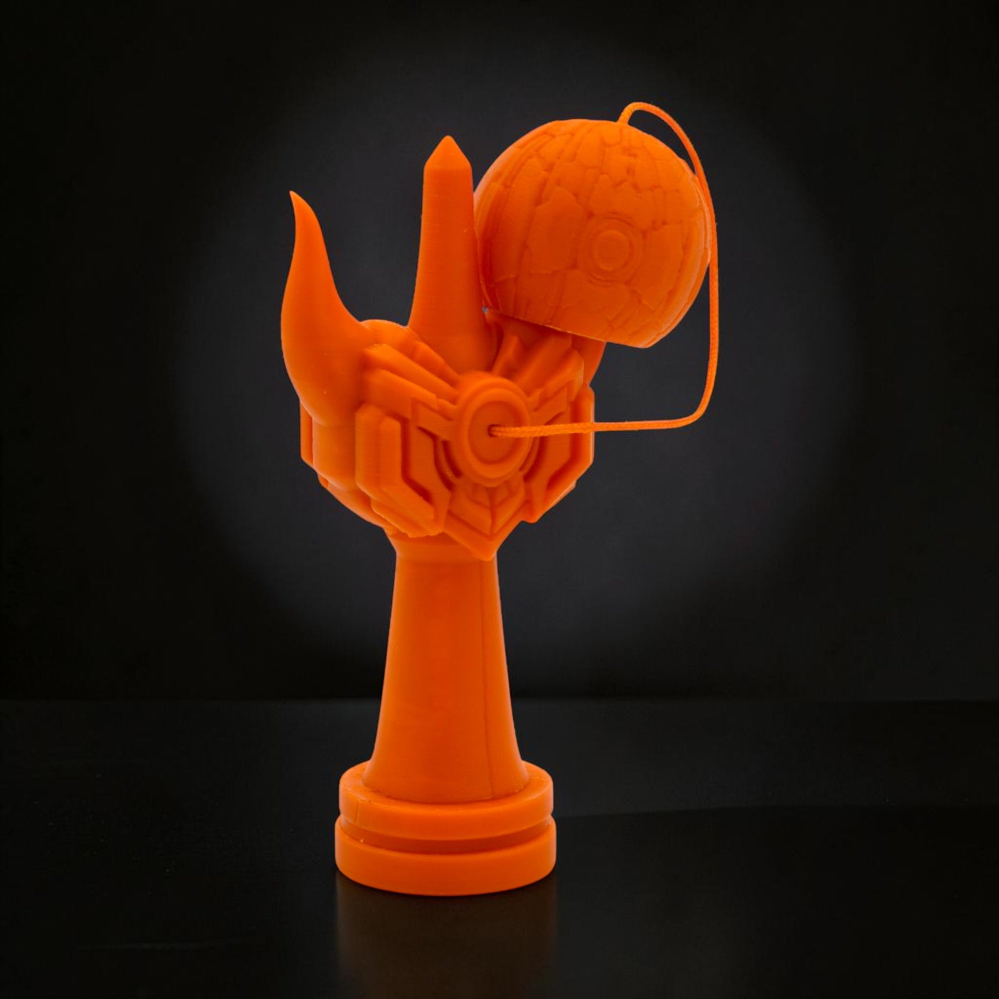 Kendama Geeker Iron S, o jucărie portocalie din fier, cu un design futurist, inspirat de armuri.