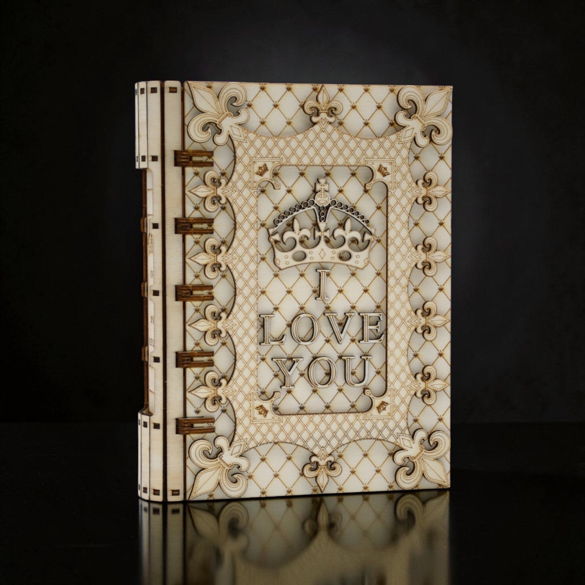 Cutie cadou Tom GO din lemn, în formă de carte, cu mesajul "I LOVE YOU" și o coroană regală, decorată cu motive florale și geometrice.