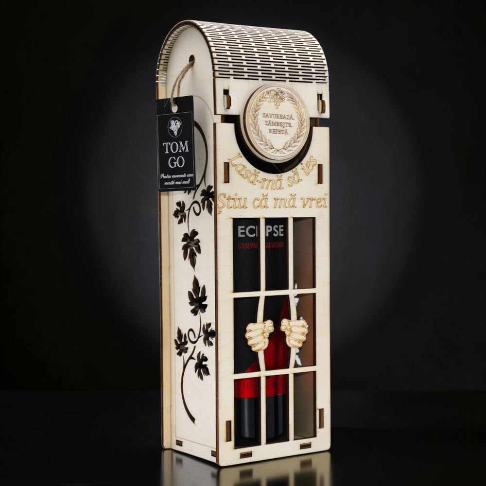 Cutie de vin din lemn Tom GO, cu design de celulă și mâini care cer eliberare, inscripționată "Lasă-mă să ies, știu că mă vrei!"