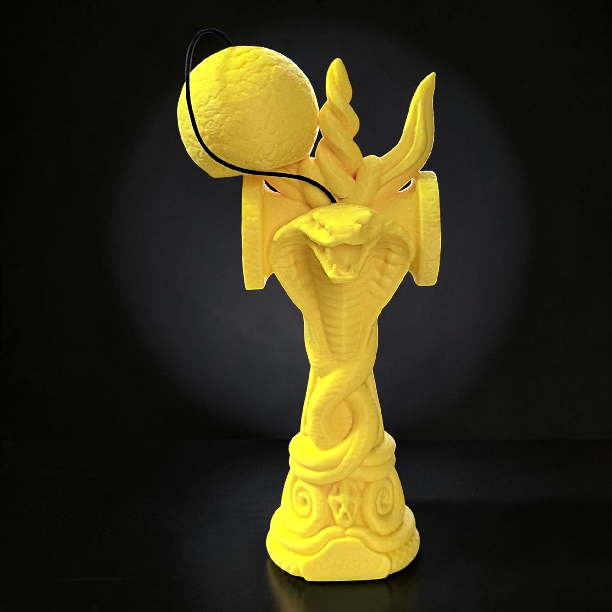 Jucărie Kendama Tom GO Cobra din lemn de fag, galben, cu design detaliat de șarpe încolăcit.