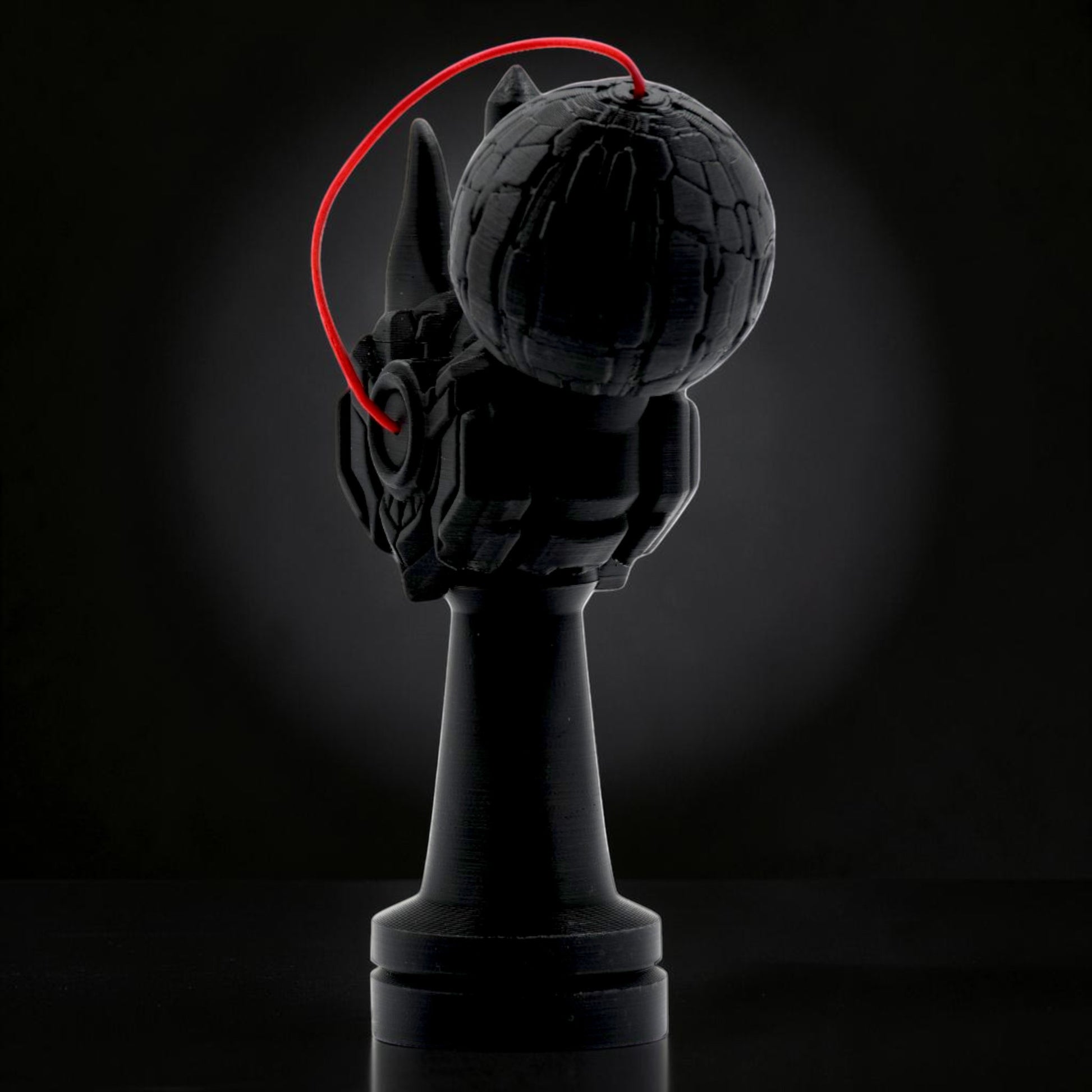 Tom Go Kendama Geeker Iron M, black, with intricate detailing on the cup and a red string.