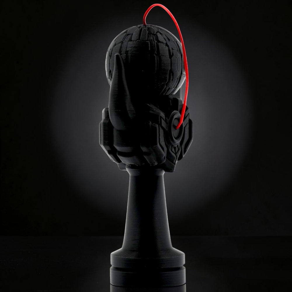 Tom Go Kendama Geeker Iron M black kendama with a red string and intricate hand design.