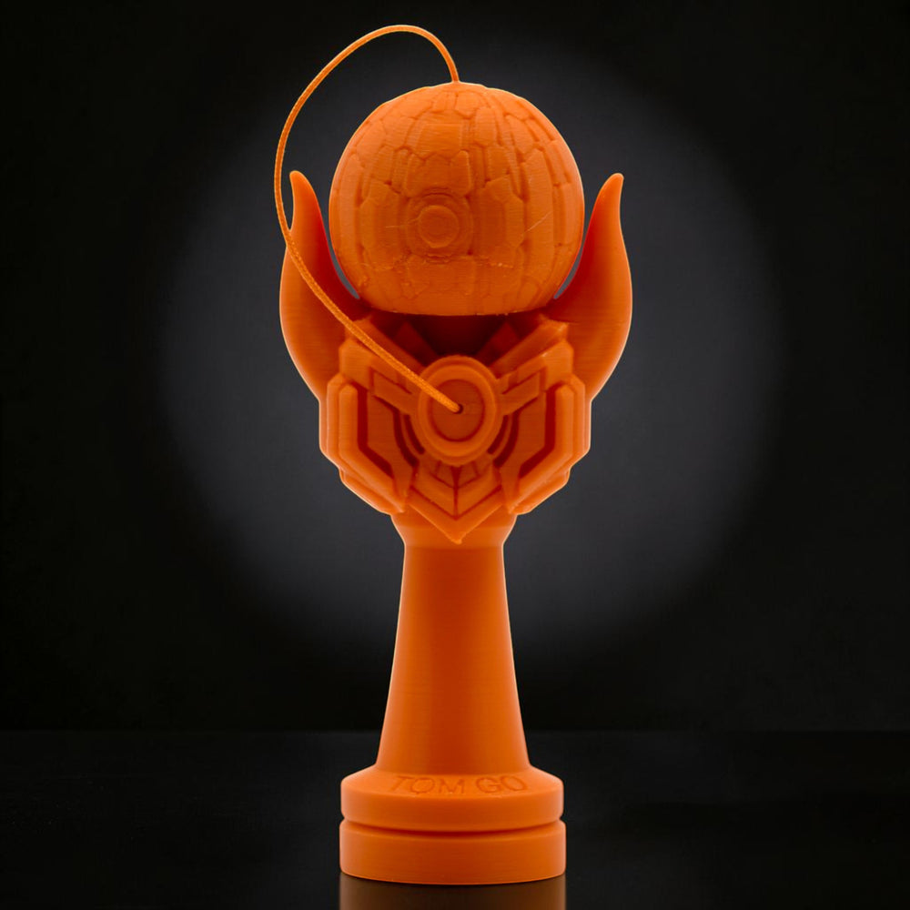 Tom GO Kendama Geeker Iron M, orange, with intricate design on the tama and a stylized base.