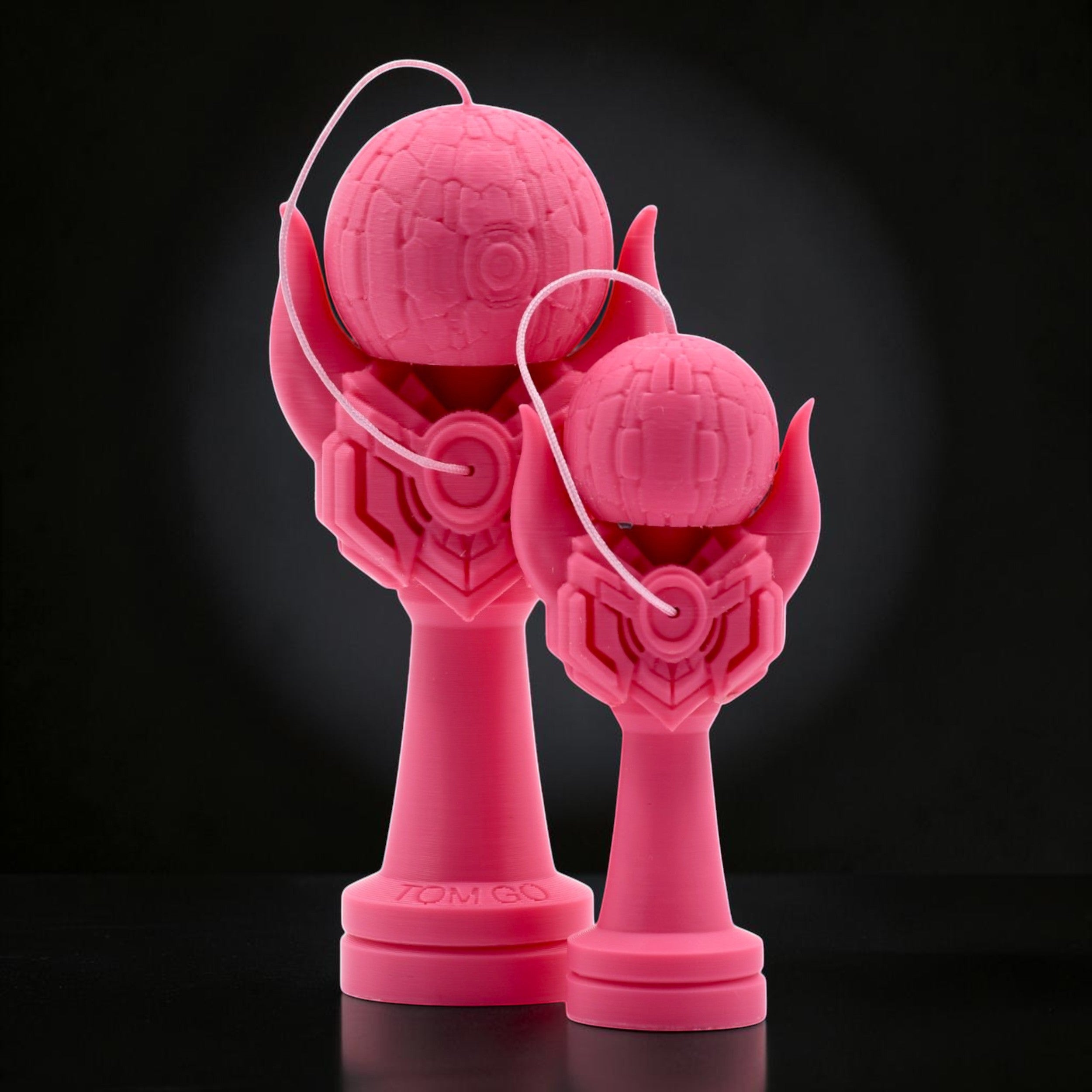 Tom GO Kendama Geeker Iron M, a bright pink 3D printed kendama toy with a unique, futuristic design. Features a textured tama and a stylized cup with intricate geometric patterns.