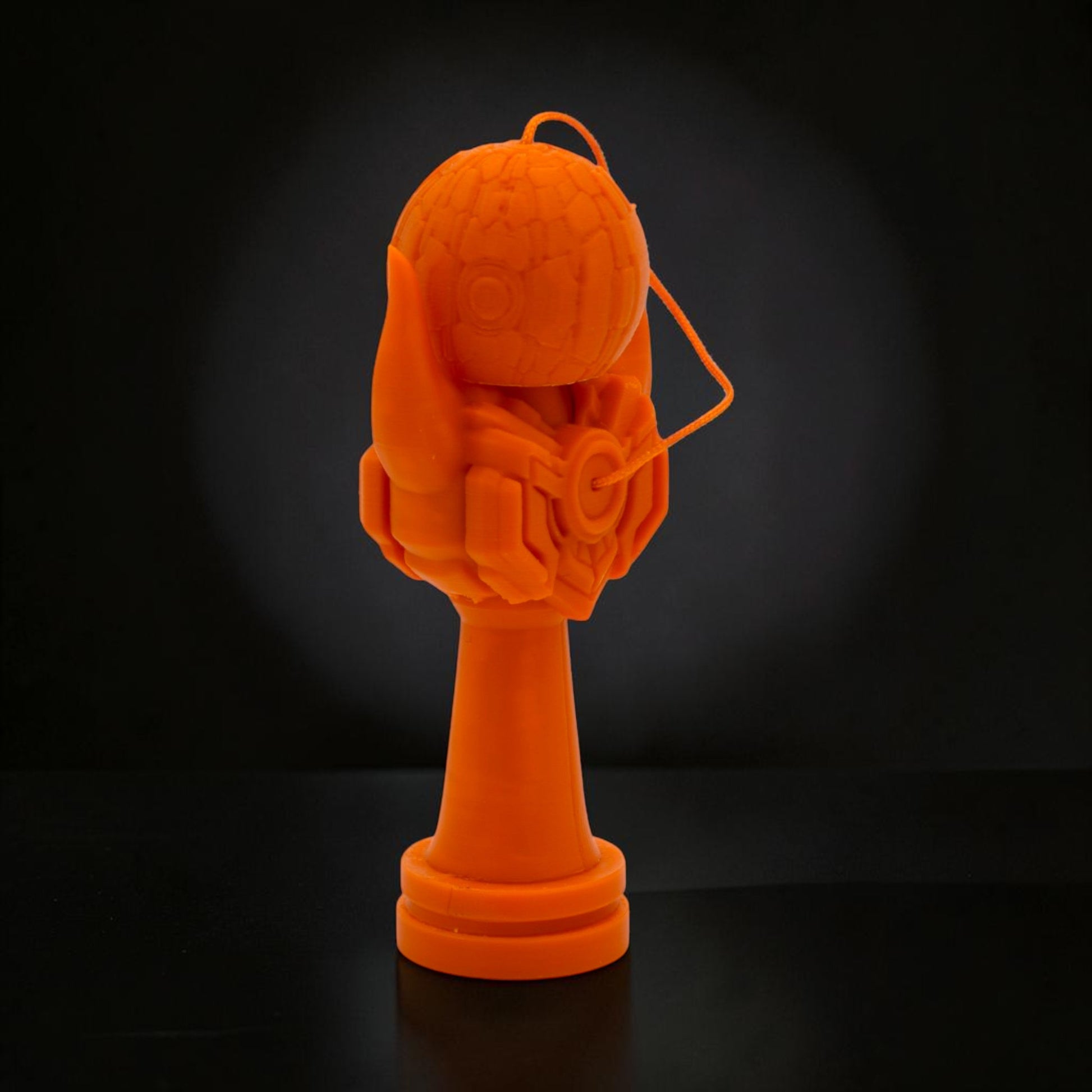 Kendama Geeker Iron S, o jucărie portocalie din plastic, cu un design futurist, inspirat de armură.