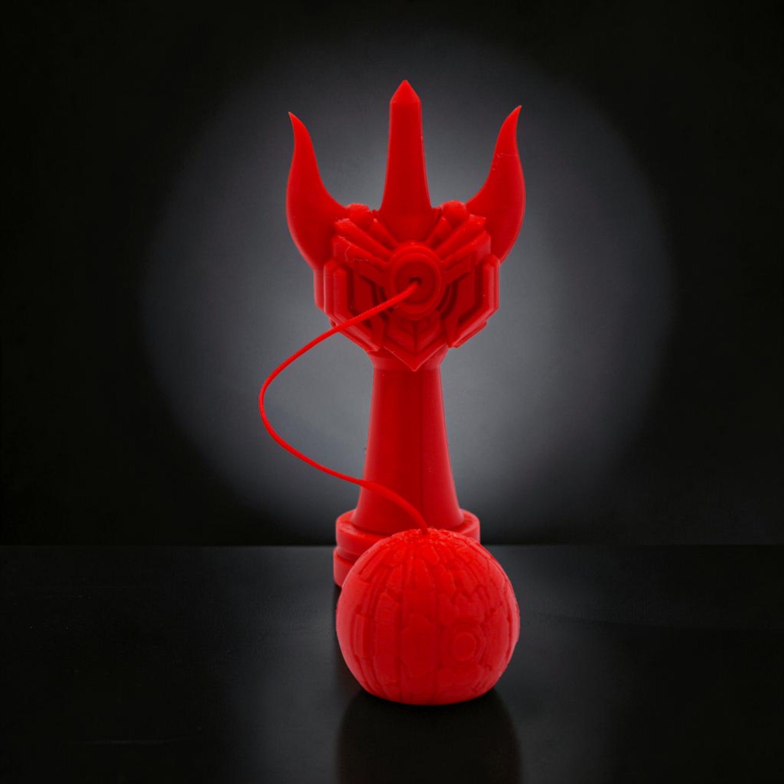 Kendama Geeker Iron S roșu, din fier, cu un design inspirat de armură, pentru control și precizie.