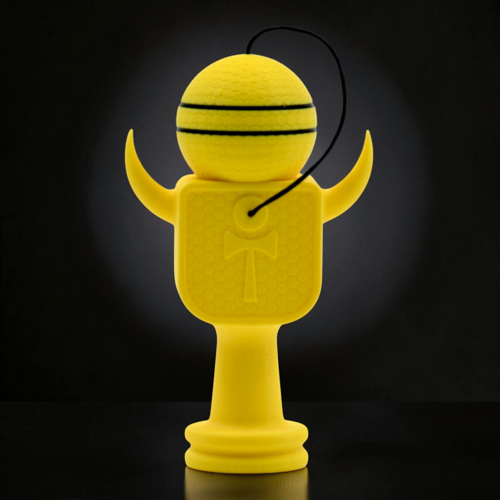 Tom GO Kendama Geeker XLine M galben, din plastic rezistent, cu design de albina si dungi negre pe bila.