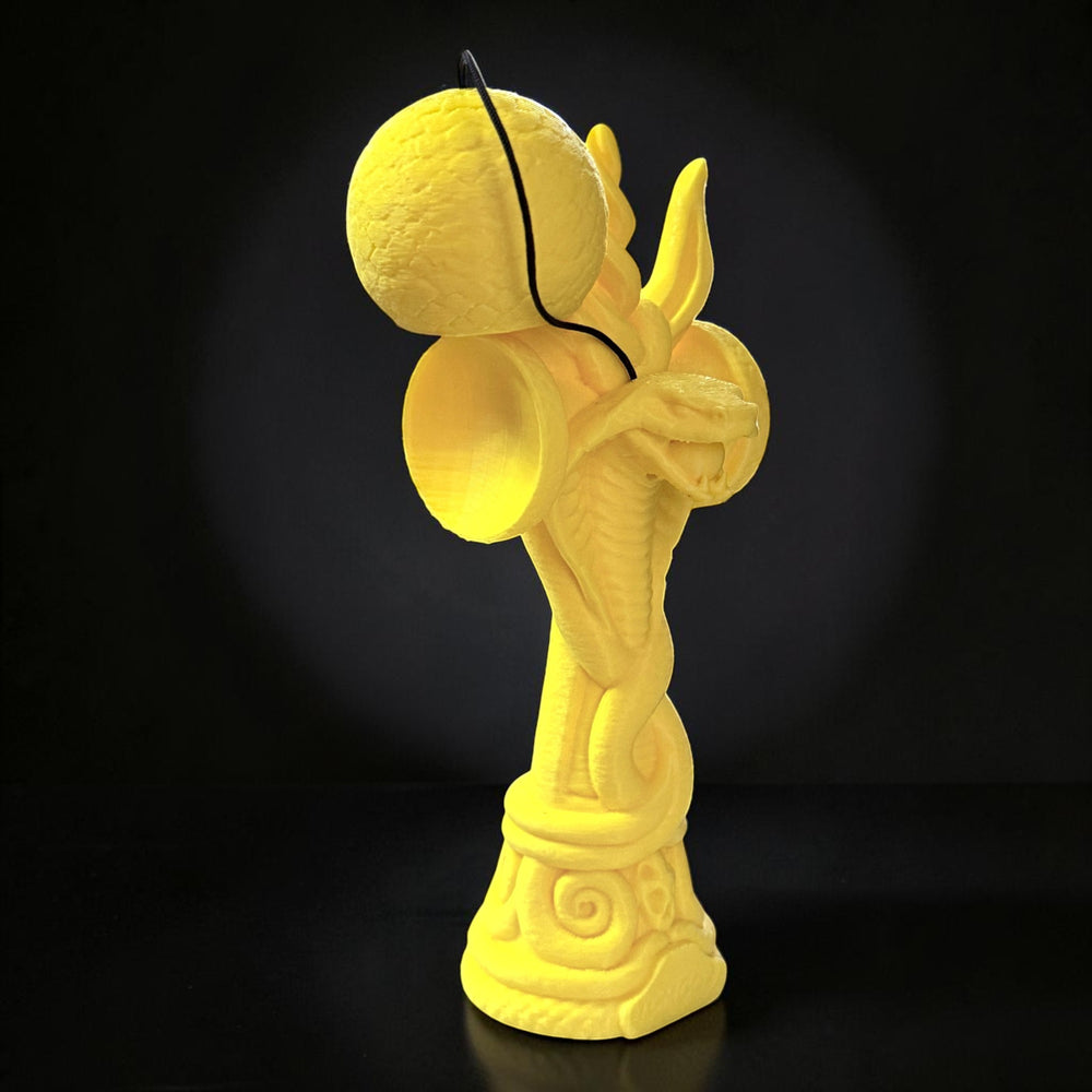 Jucărie Kendama Cobra din lemn de fag, galben, cu design detaliat de șarpe încolăcit, ideală pentru colecționari.