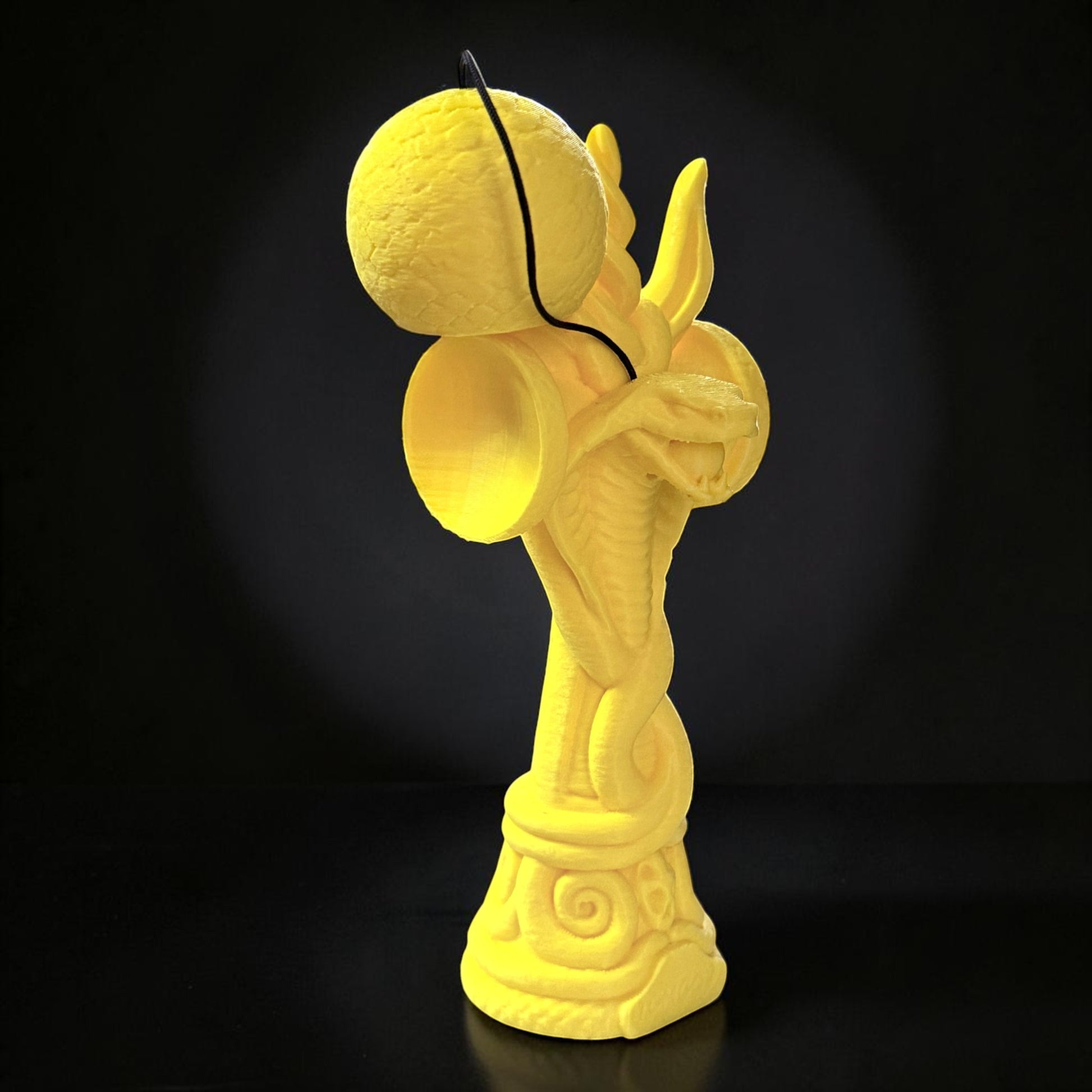 Jucărie Kendama Cobra din lemn de fag, galben, cu design detaliat de șarpe încolăcit, ideală pentru colecționari.