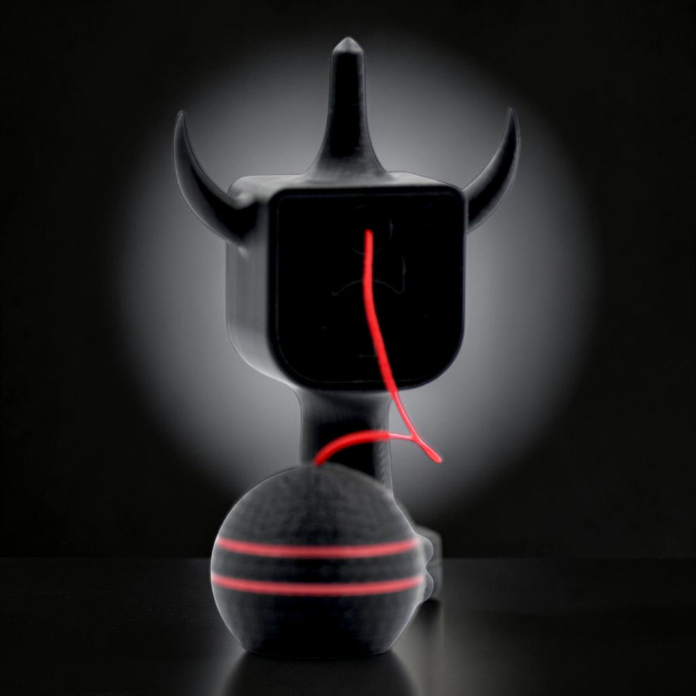 Kendama Geeker XLine M neagră, cu șnur roșu, din plastic rezistent, cu design de diavol.