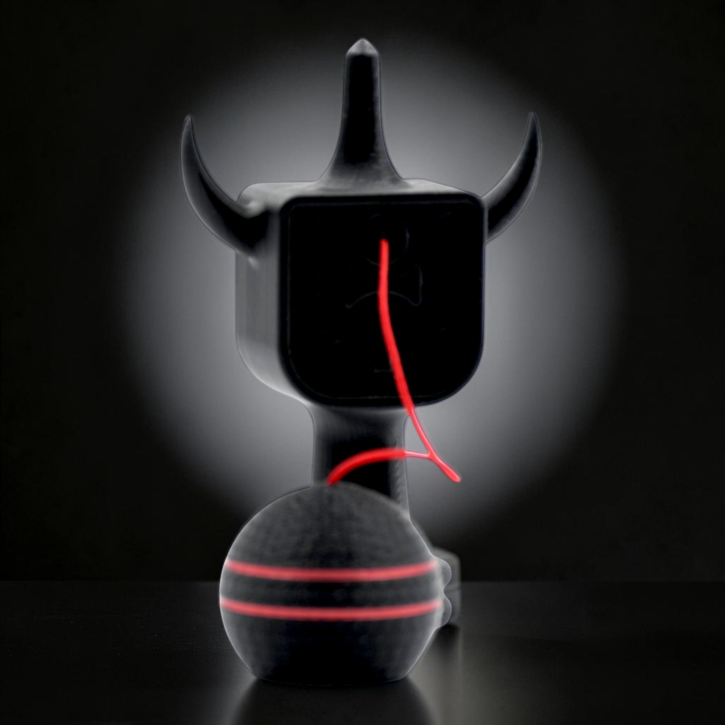 Kendama Geeker XLine M neagră, cu șnur roșu, din plastic rezistent, cu design de diavol.