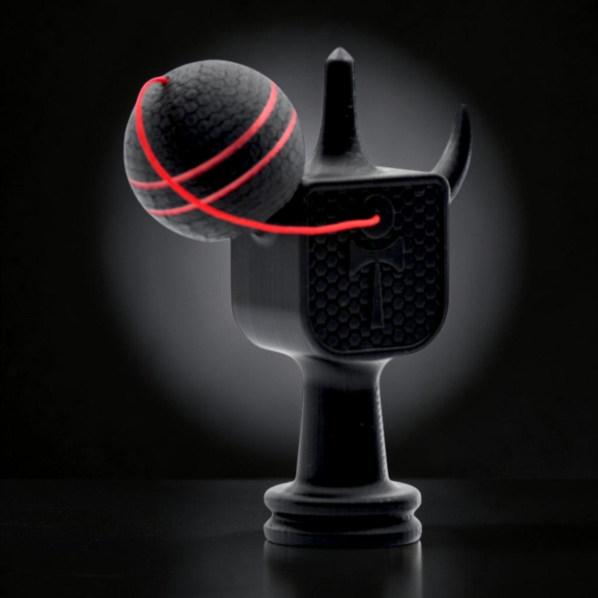 Kendama Geeker XLine M neagră, cu șnur roșu, din plastic rezistent, pentru jocuri de îndemânare.