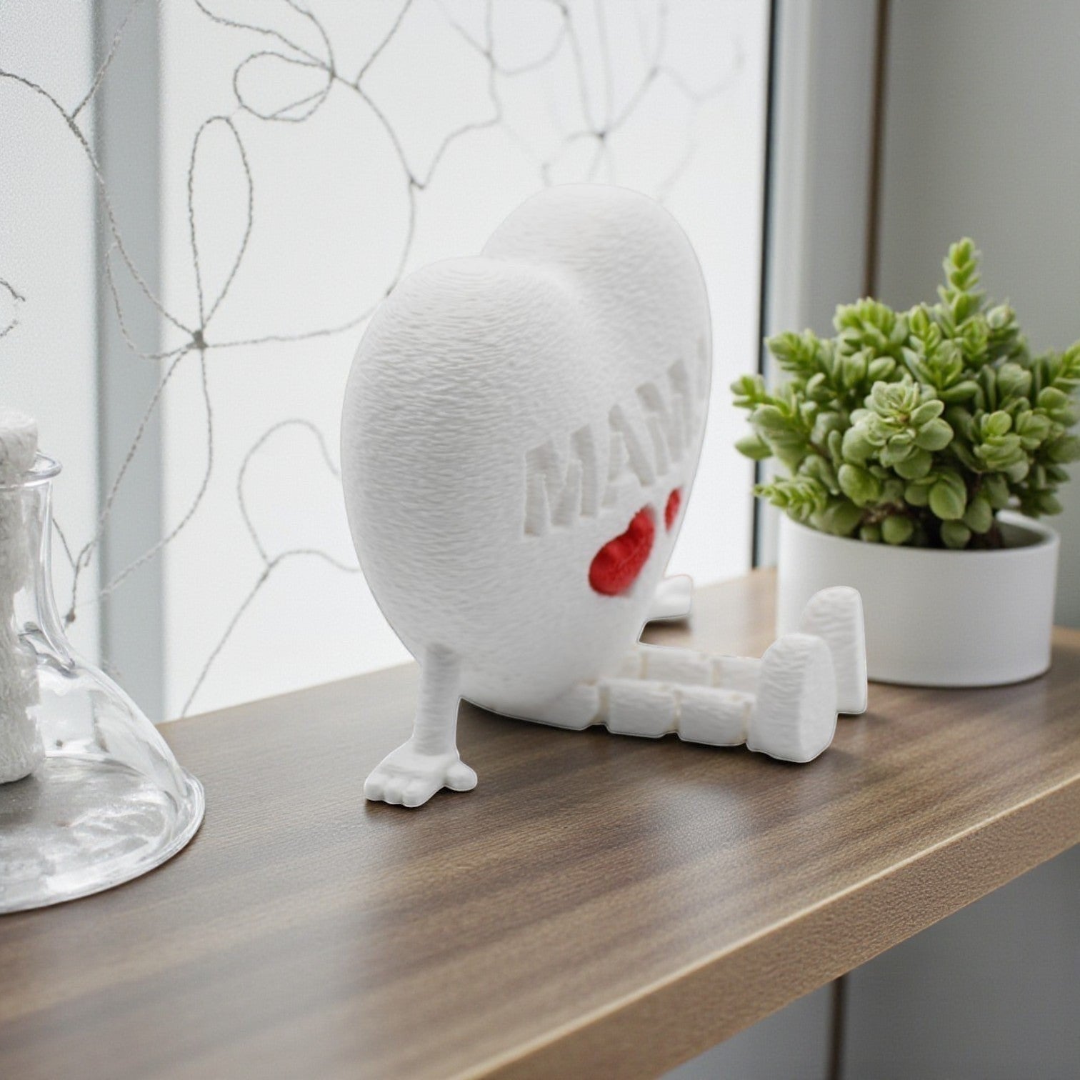 Tom Goh white textured heart figurine with articulated legs, embossed with MAMA and two red hearts.
